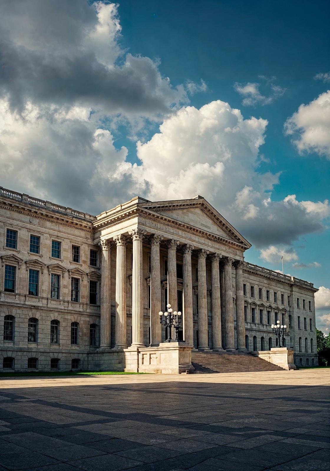 A neoclassical government building with tall columns and a wide staircase stands beneath a partly cloudy sky—a classic setting where a mandamus lawyer might advocate for justice.